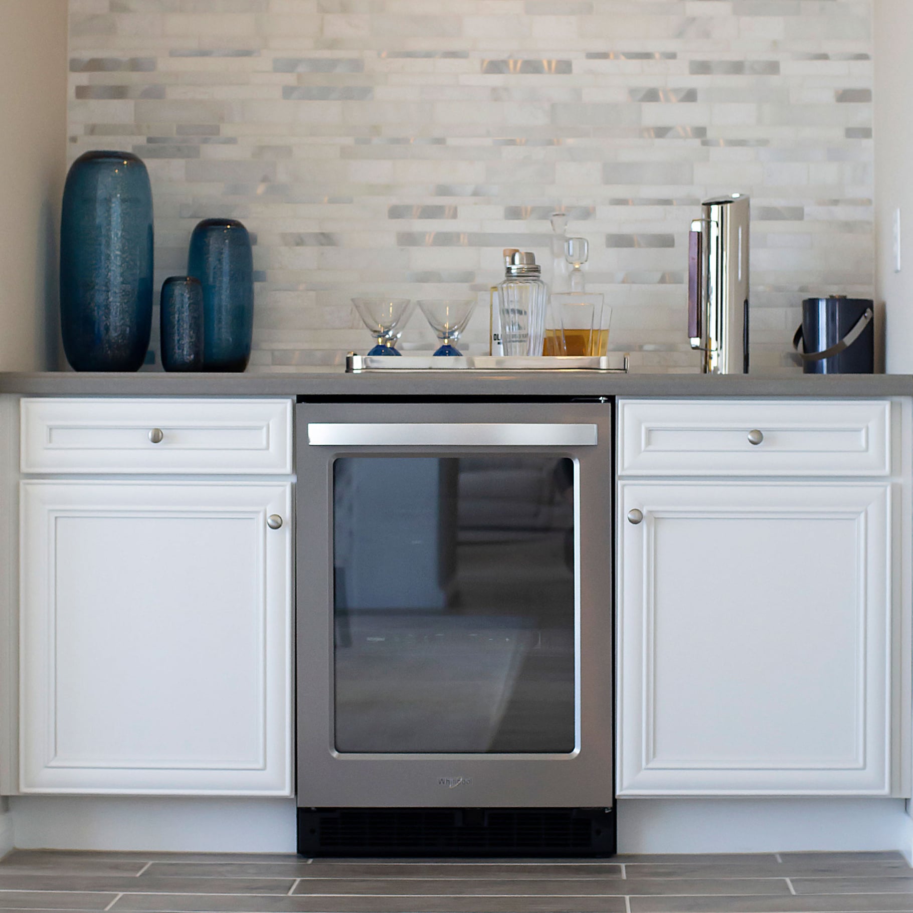 home bar with white cabinets and gray countertop