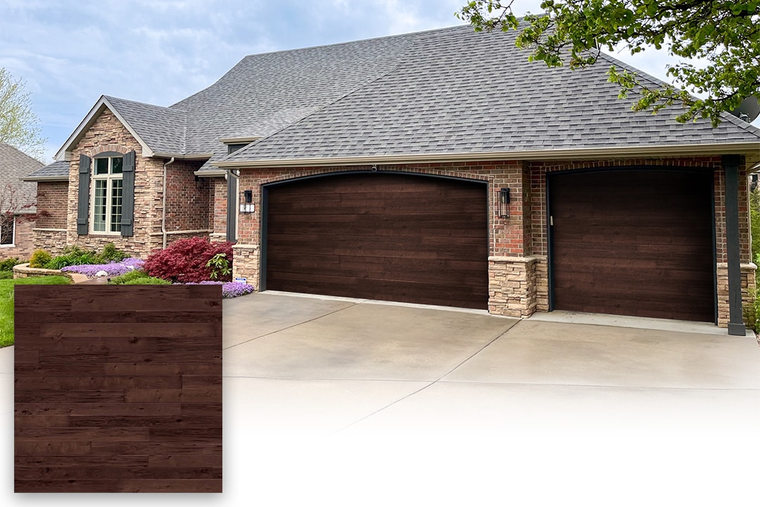 stone and brick home with woodtone garage doors