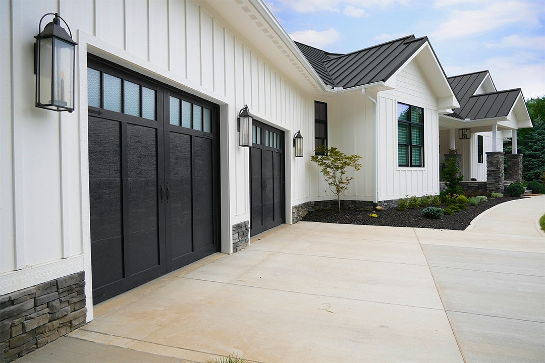 black garage doors on home with white siding