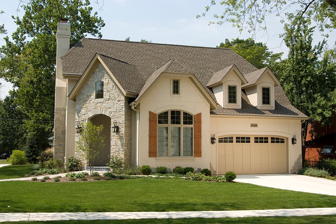 tan garage door on stone house