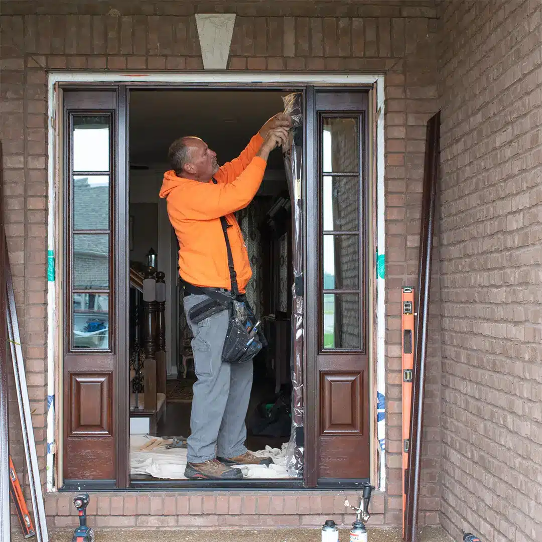 skilled trades worker removing plastic packaging from new entry door