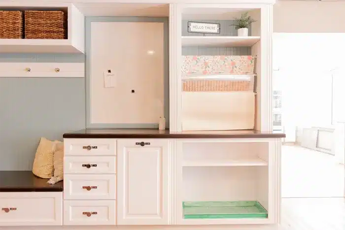 white cabinetry drop zone with wood countertop