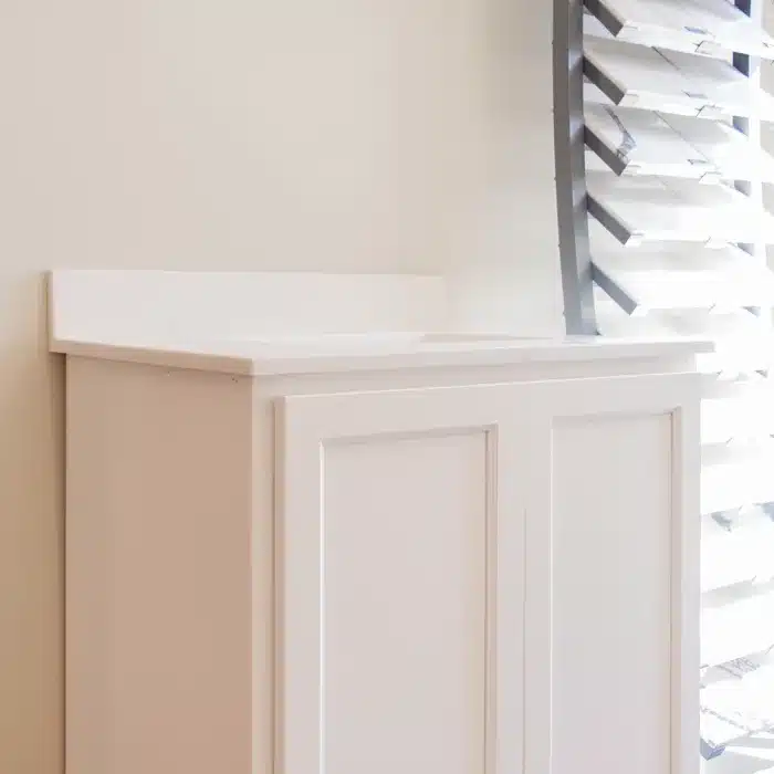 white vanity cabinet with two doors and marble top