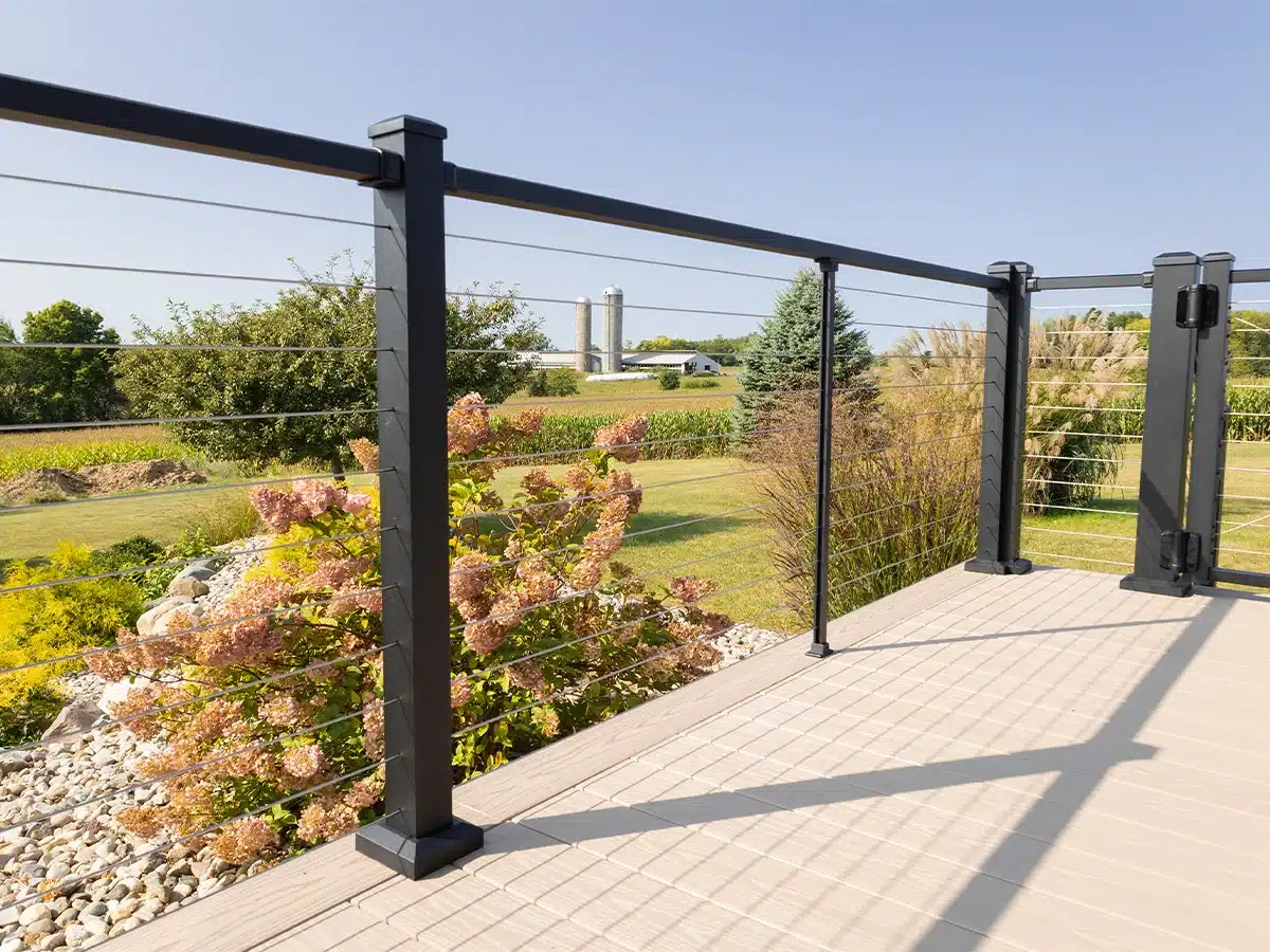 black horizontal cable railing on backyard deck in rural area