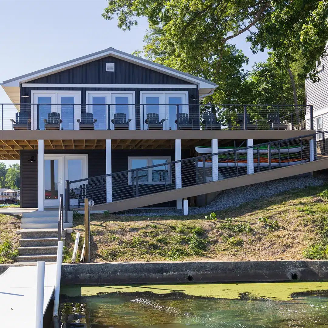 residential deck with black railing and white columns