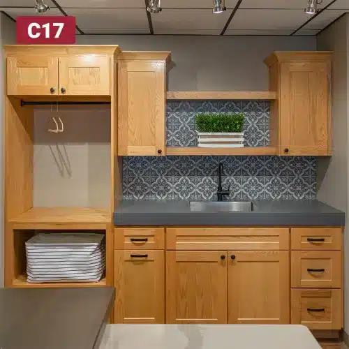 laundry room cabinetry with light stain and dark countertop