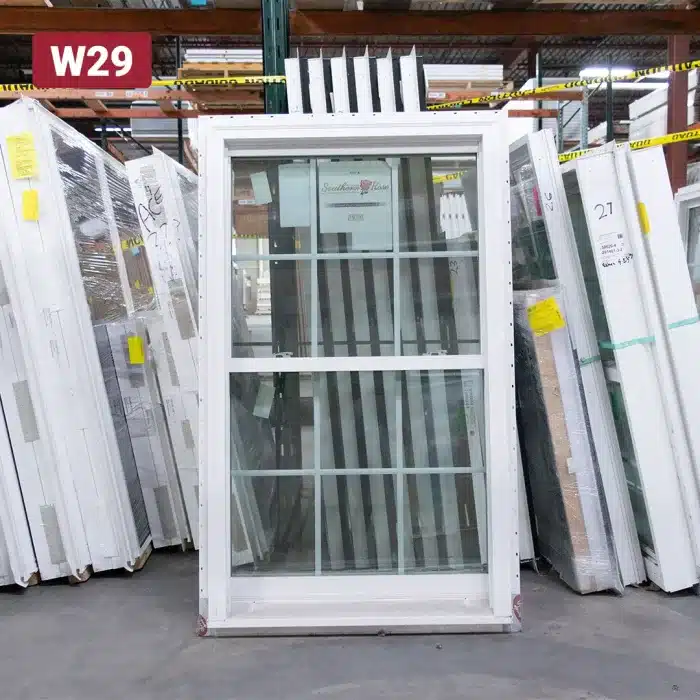 white vinyl double hung window leaning up against warehouse racking